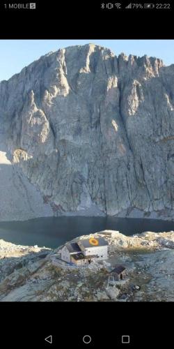 a house on an island in front of a mountain at Casa vacanze jsabel in Pieve Tesino