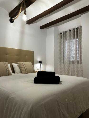 a bedroom with a large bed with a black pillow on it at Apartamento Casco Histórico Tarazona in Tarazona de Aragón