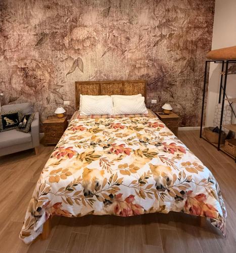 a bed with a floral comforter in a bedroom at Maison Frida • Tivoli in Tivoli