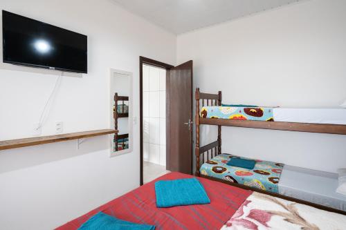 a bedroom with a bunk bed and a television at 06 Residencial Lazzaris a poucos metros do Beto Carrero in Penha