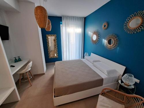 a blue bedroom with a bed and a sink and mirrors at Le Dune Luxury Rooms in Vieste