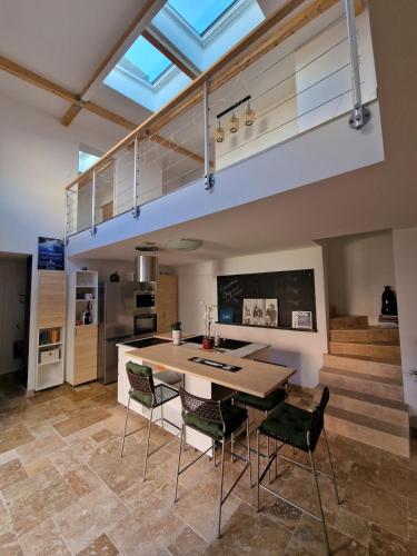 une cuisine avec une table et des chaises dans une pièce dans l'établissement Maison neuve 116m2, climatisée, Wi-Fi, à Oullins