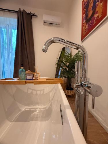 a white bath tub with a faucet in a bathroom at Maison Frida • Tivoli in Tivoli