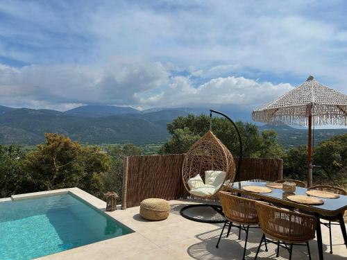 a patio with a table and chairs next to a pool at XTC Villas Kefalonia - Villa X in Argostoli