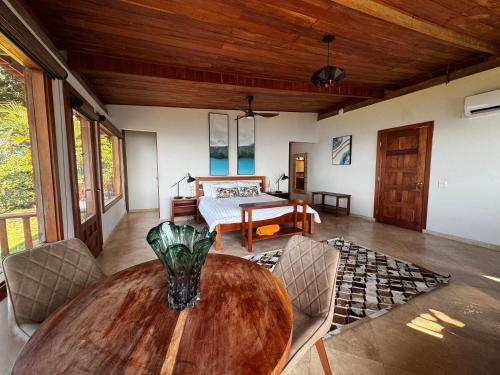 a dining room with a table and a bedroom at Ciel y Miel in Colón