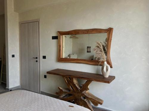 a mirror on a wall next to a wooden table at XTC Villas Kefalonia - Villa X in Argostoli