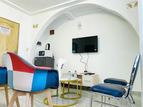 Télévision ou salle de divertissement dans l'établissement NAIVELI-PALM Appartement meublé sobre et chic