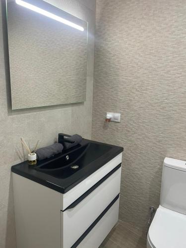 a bathroom with a black sink and a mirror at Casa Pepa in Fuenmayor