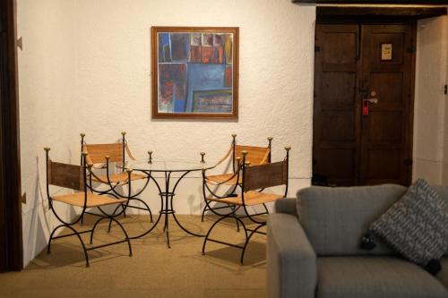 a table and chairs in a living room with a couch at Hotel Museo Spa Casa Santo Domingo in Antigua Guatemala