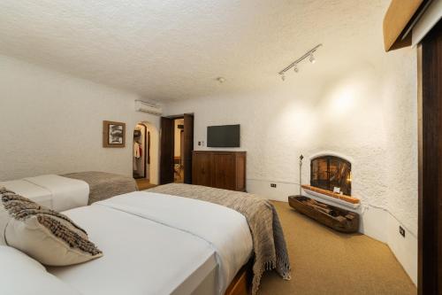 a bedroom with two beds and a fireplace at Hotel Museo Spa Casa Santo Domingo in Antigua Guatemala