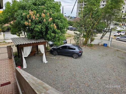 a car parked in a parking lot next to a tree at 06 Residencial Lazzaris a poucos metros do Beto Carrero in Penha