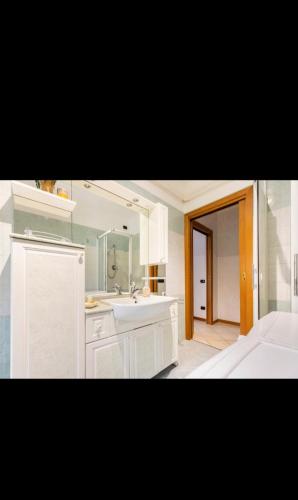 a white bathroom with a sink and a mirror at Casa vilma in Peschiera del Garda