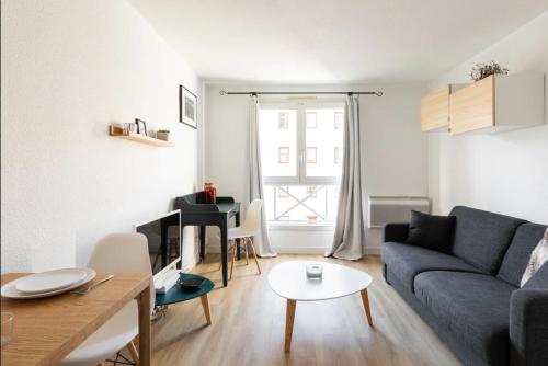 un salon avec un canapé bleu et une table dans l'établissement Royal Suite Lyon 7, à Lyon