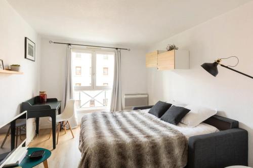 une chambre avec un lit, un bureau et une fenêtre dans l'établissement Royal Suite Lyon 7, à Lyon