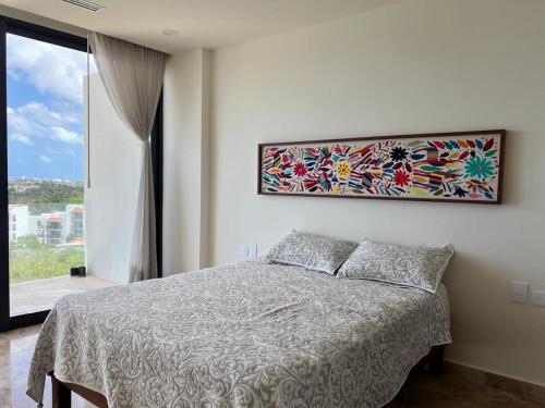 una camera da letto con un letto e un quadro sul muro di DSoleil a Cozumel