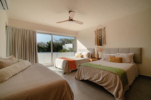 a bedroom with two beds and a window at Villa Yakunah 5min walk to lagoon oasis in Akumal