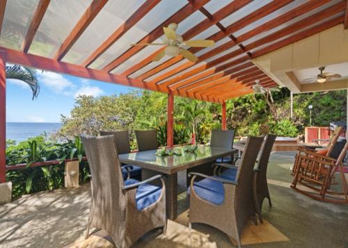 a patio with a table and chairs and the ocean at Bahia Pez Vela Resort in Ocotal
