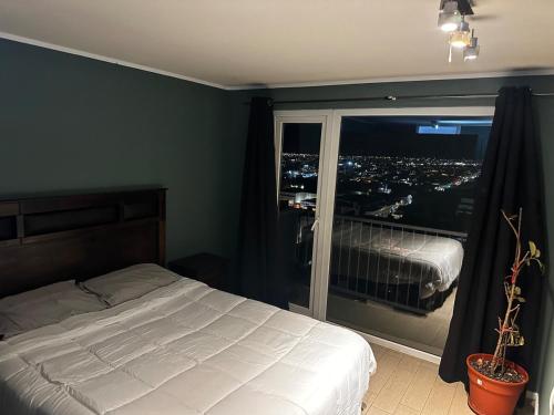 a bedroom with a bed and a large window at Espacio parque 1705 in Calama