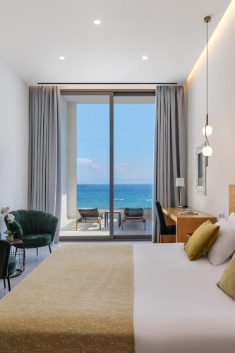 a bedroom with a bed and a view of the ocean at Mythical Coast Wellness Retreat in Mytilini