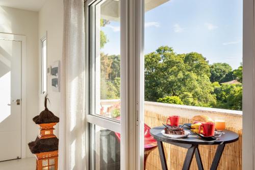 una mesa con un plato de comida en un balcón con ventana en Studio com churrasq 650m da Torre Panorâmica RME047, en Curitiba