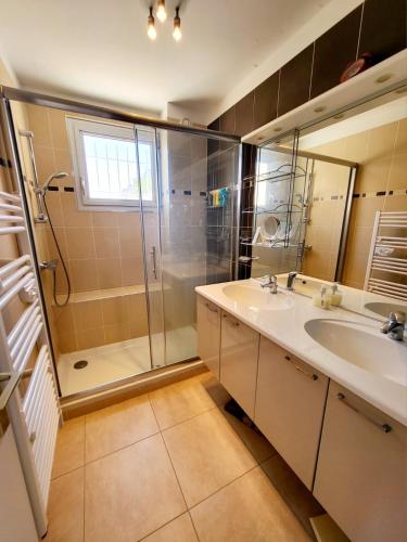 une salle de bain avec une douche, un lavabo et un miroir dans l'établissement Superbe Appartement T3 vue mer en centre ville à 5 minutes à pied de la place, à Cavalaire-sur-Mer