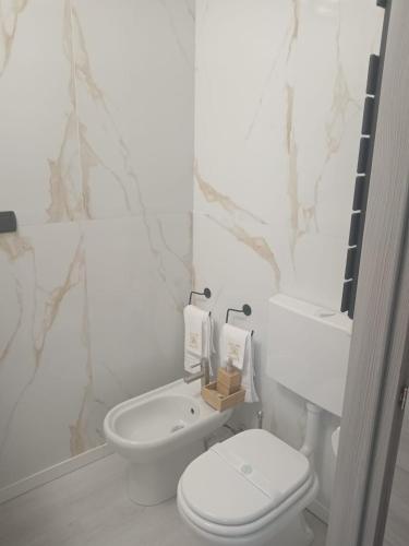 Un baño blanco con inodoro y lavabo. en Hotel Baiardo, en Romagnano Sesia