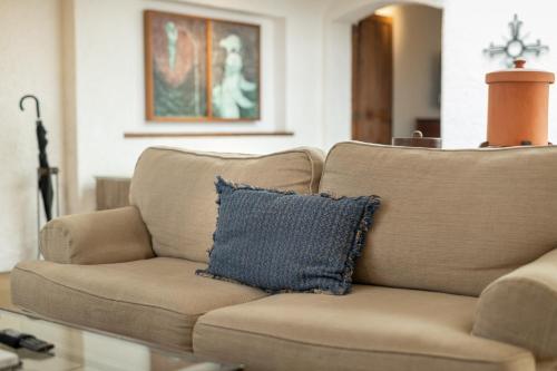 a brown couch with a blue pillow in a living room at Hotel Museo Spa Casa Santo Domingo in Antigua Guatemala