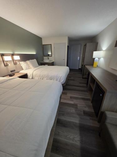 a hotel room with two beds and a desk at Dakota Inn in Minot