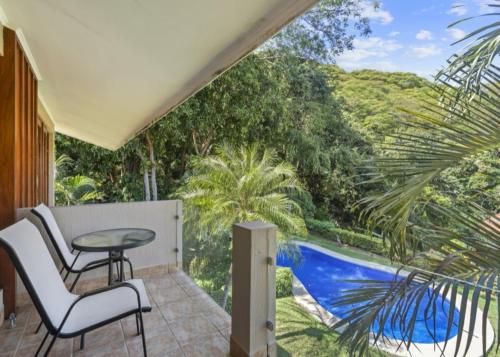 a patio with a table and chairs on a balcony at Bahia Pez Vela Resort in Ocotal
