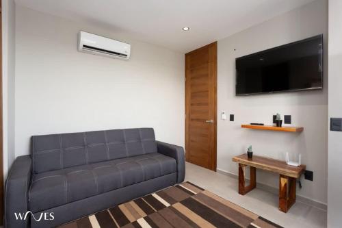 a living room with a couch and a table at 1 bedroom with park view in condominium with gym sauna and steam room in Tulum