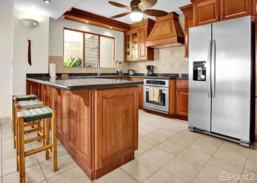 a kitchen with wooden cabinets and a stainless steel refrigerator at Bahia Pez Vela Resort in Ocotal