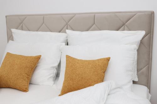 a pile of white pillows on a bed at Central Rooftop Apartment in Trebinje