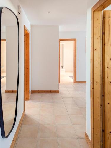 a hallway with a mirror and a tile floor at Spacieux appartement Morgins cheminée, terrasse et jardin in Morgins