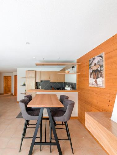 a kitchen and dining room with a table and chairs at Spacieux appartement Morgins cheminée, terrasse et jardin in Morgins
