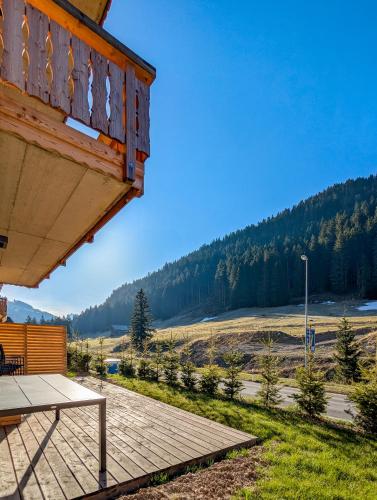 a wooden porch of a house with a picnic table at Spacieux appartement Morgins cheminée, terrasse et jardin in Morgins