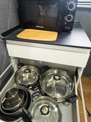 a stove top with four pots and pans on it at Apartamento muy cerca de playas ocio y restauración en Candelaria Tenerife in Candelaria