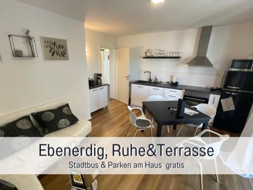 a kitchen and a living room with a couch and a table at OLIVE - Ruhe & Entspannung in 2-Zi-Fewo mit Garten-Whirlpool, Terrasse & Hund willkommen by FerienWohnenAmSee in Überlingen