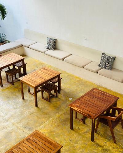 a living room with wooden tables and a couch at Freelance Hostel in Tulum