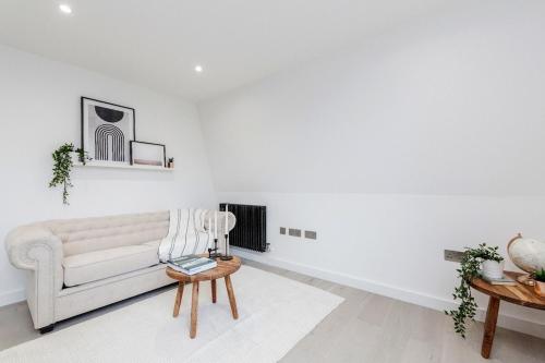 a white living room with a couch and a table at 2Bed 2Bath Apartment in Liverpool Street, Steps to Brick Lane, Spitalfields & Shoreditch in London