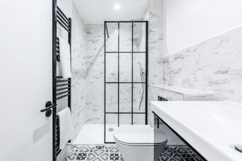 a white bathroom with a toilet and a sink at 2Bed 2Bath Apartment in Liverpool Street, Steps to Brick Lane, Spitalfields & Shoreditch in London