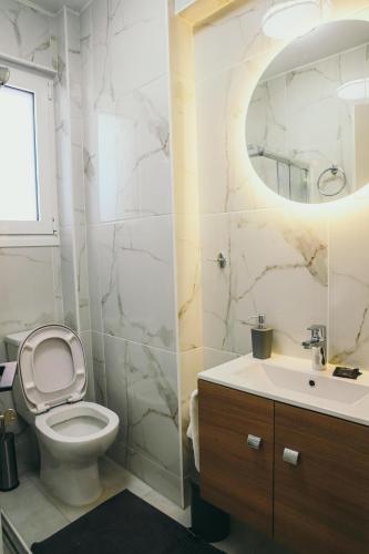 a bathroom with a toilet and a sink and a mirror at Liebe 16 luxurious stay in Volos