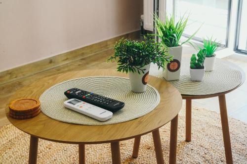 a table with two remote controls and potted plants on it at Liebe 16 luxurious stay in Volos