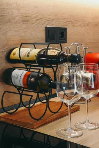 a rack of wine bottles and glasses on a table at Liebe 16 luxurious stay in Volos