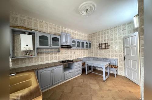 una cucina con mobili blu e un tavolo di Dar el Karama a Kelibia