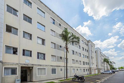 a large white building with a motorcycle parked next to it at Confortável apartamento, com wi-fi, pet friendly in Votorantim