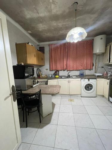 mała kuchnia ze stołem i zlewem w obiekcie zainab house w mieście Amman