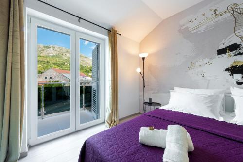 een slaapkamer met een paars bed en een groot raam bij Villa Gold Residence 2 in Mlini