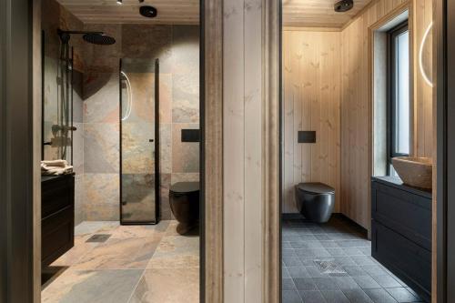 a bathroom with a shower and a toilet and a sink at Hydla Mountain Lodge in Stryn