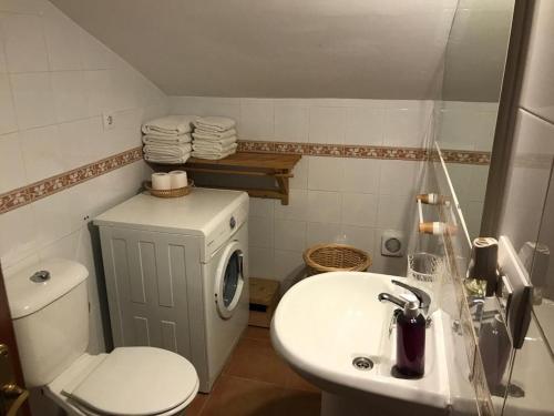 a bathroom with a white toilet and a sink at El Bosque Rural House in El Bosque