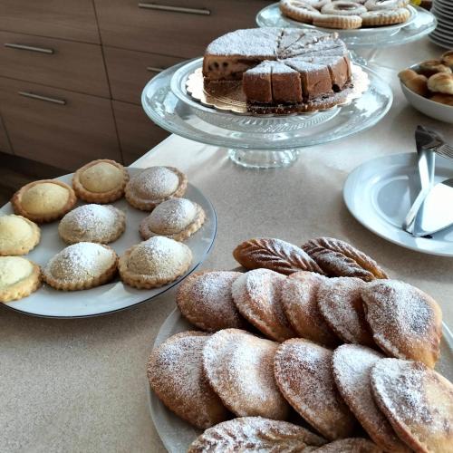 a table topped with plates of pastries and cakes at Cofanomare in Custonaci